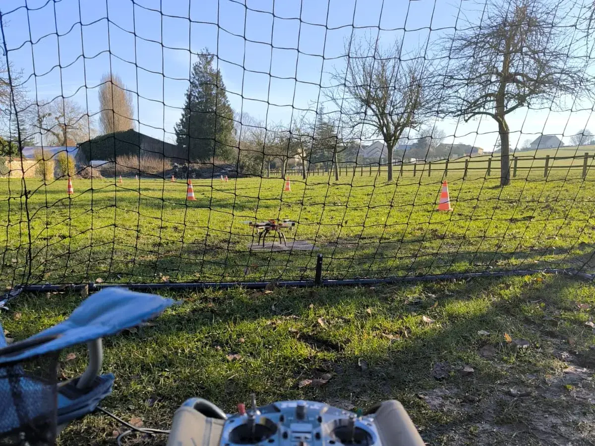 Radiocommande de drone posée au sol sur le terrain de vol, en attente d'un vol de mission