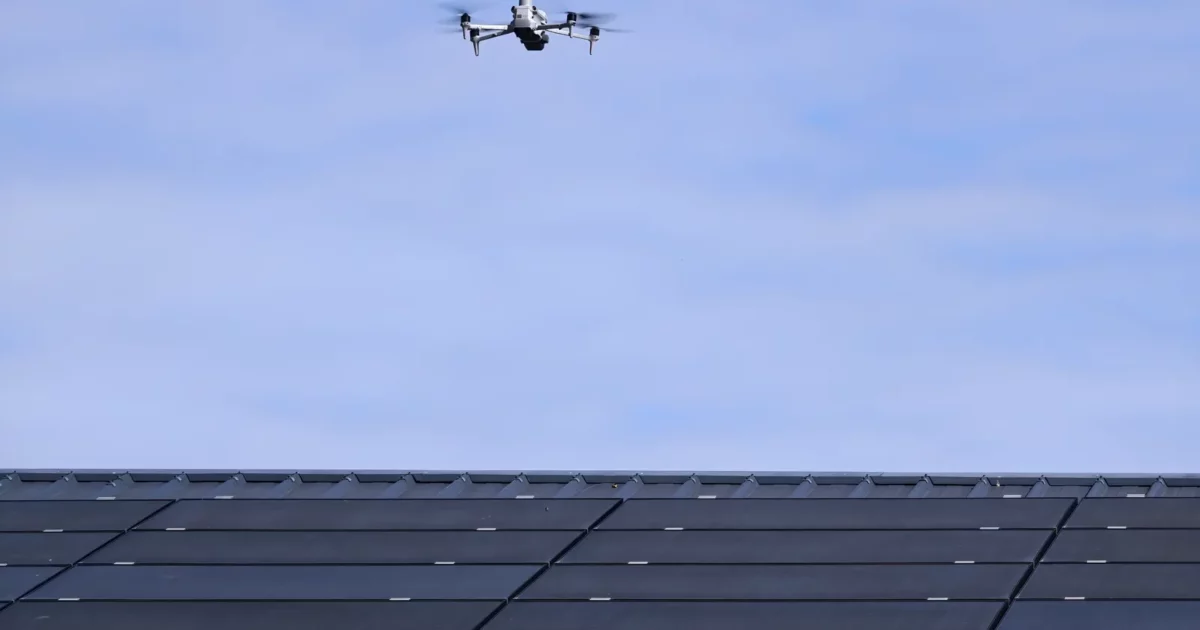 Drone à caméra thermique en vol au-dessus d'une toiture de panneaux photovoltaïques pendant la formation thermographie par drone TELEPILOTE à Marcq (78)