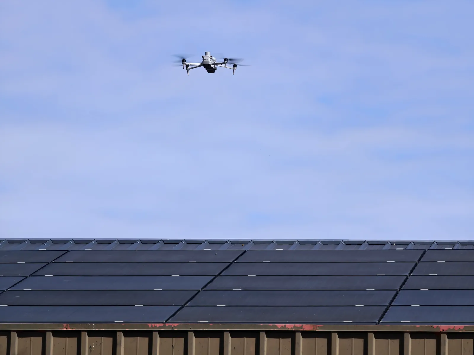 Drone à caméra thermique en vol au-dessus d'une toiture de panneaux photovoltaïques pendant la formation thermographie par drone TELEPILOTE à Marcq (78)