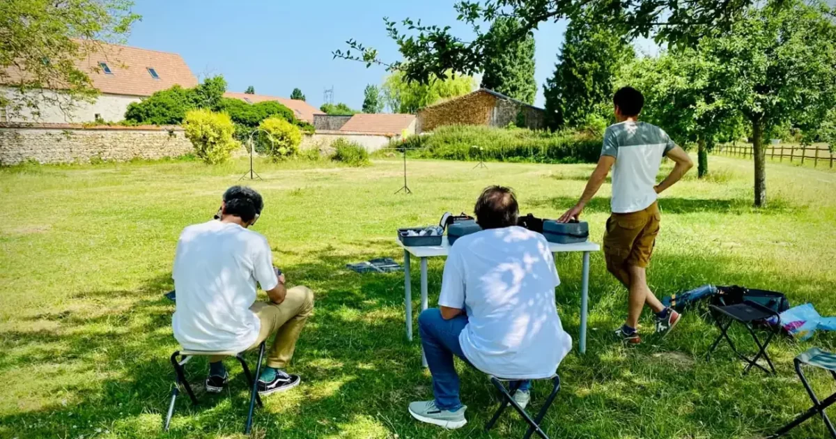Stagiaires travaillant sur des tables en extérieur à la préparation d'un dossier de mission drone au campus TELEPILOTE de Marcq